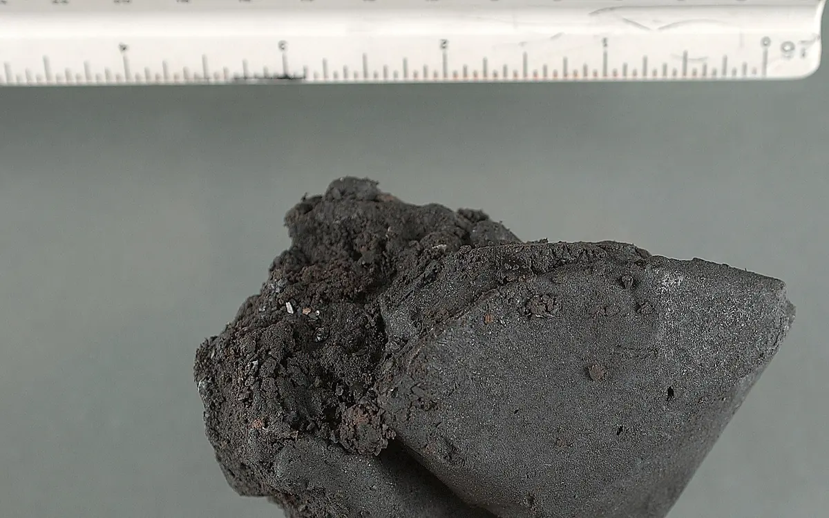 Ein dunkler klebriger Klumpen Black Tar Heroin neben einem Lineal