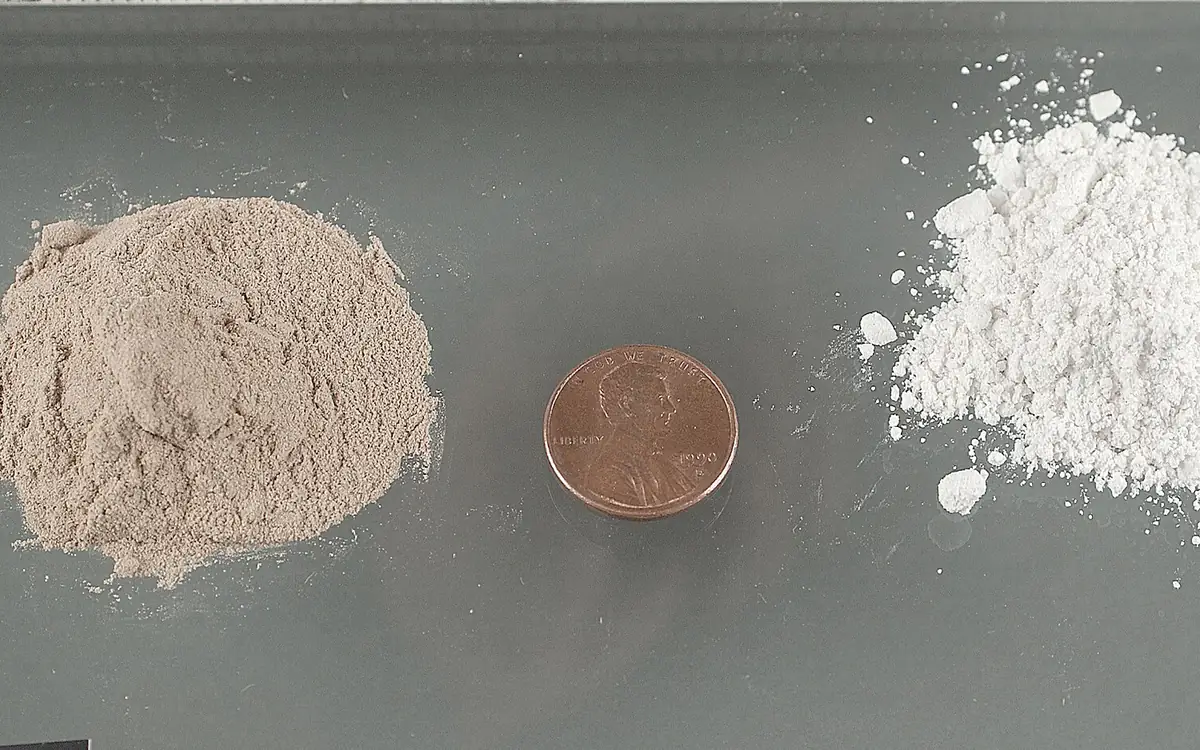 Ein beigefarbenes und ein weißes Heroinpulver nebeneinander, dazwischen eine Ein-Cent-Münze